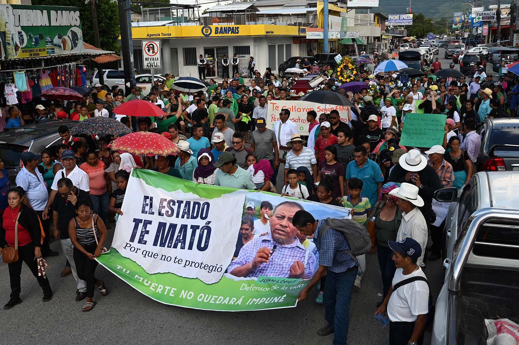 People hold a banner reading &ldquo;the state killed you&rdquo; during environmental leader Juan Lopez&rsquo;s funeral in the municipality of Tocoa, department of Colon, on 16 September 2024. Photo by Orlando Sierra/AFP via Getty Images.