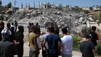 Palestinians gather at a residential building after Israeli excavators demolished it in the town of Beit Ummar, north of the West Bank city of Hebron, on April 21, 2025.